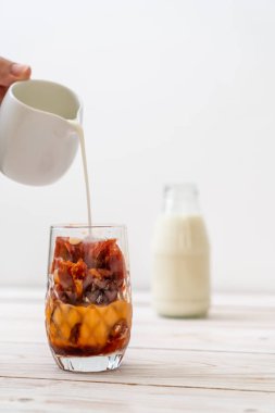 Tay çay buz küpü ile ahşap arka plan üzerinde süt