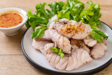 Soslu ve sebzeli haşlanmış balık sosu.