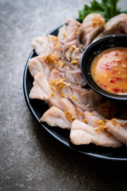 Soslu ve sebzeli haşlanmış balık sosu.