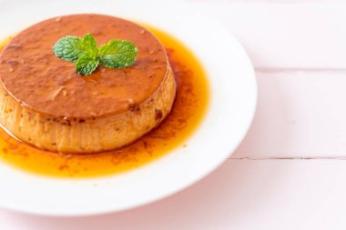 Ev yapımı karamel kremalı puding ahşap arka plan üzerinde