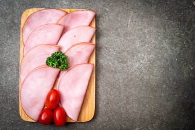 Ahşap tahta üzerinde dilimlenmiş jambon füme