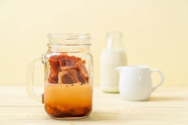 Tay çay buz küpü ile ahşap arka plan üzerinde süt