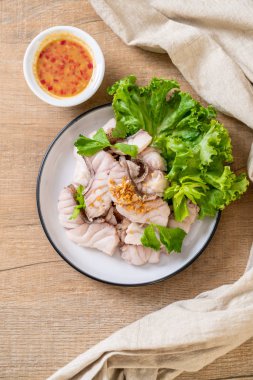 Soslu ve sebzeli haşlanmış balık sosu.