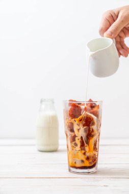 Tay çay buz küpü ile ahşap arka plan üzerinde süt