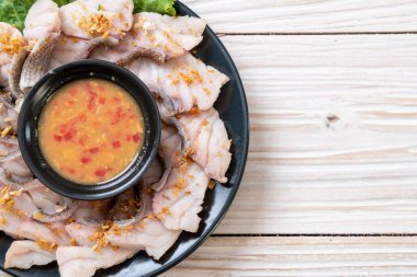 Soslu ve sebzeli haşlanmış balık sosu.