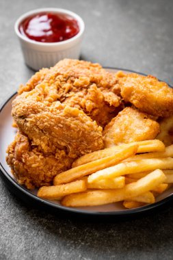 Kızarmış tavuk, patates kızartması ve nugget yemeği. Abur cubur ve sağlıksız yemek.