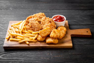 Kızarmış tavuk, patates kızartması ve nugget yemeği. Abur cubur ve sağlıksız yemek.