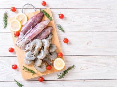 taze deniz ürünleri ham (karides, mürekkep) malzemelerle ahşap tahta üzerinde