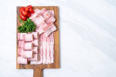 Ahşap tahta üzerinde çiğ domuz pastırma dilimlenmiş
