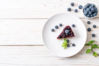 Ahşap arka planda ev yapımı yaban mersinli kek.