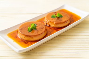 Ev yapımı karamel kremalı puding ahşap arka plan üzerinde