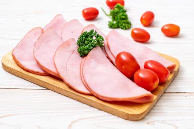 Ahşap tahta üzerinde dilimlenmiş jambon füme