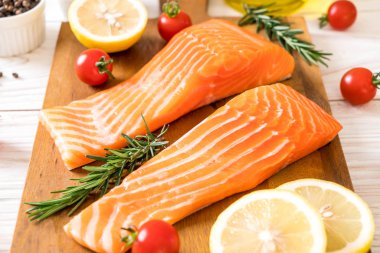 Limon domates Biberiye Biber ve tuz ahşap tahta üzerinde Çiğ somon fileto