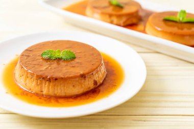 Ev yapımı karamel kremalı puding ahşap arka plan üzerinde