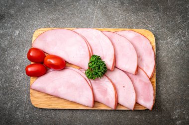 Ahşap tahta üzerinde dilimlenmiş jambon füme