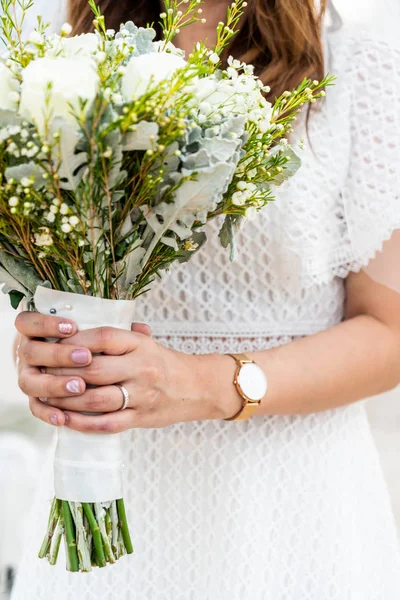 bride hand holding flower bouquet for wedding - selective focus point