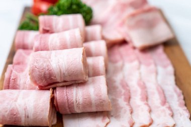 Ahşap tahta üzerinde çiğ domuz pastırma dilimlenmiş