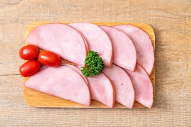 Ahşap tahta üzerinde dilimlenmiş jambon füme
