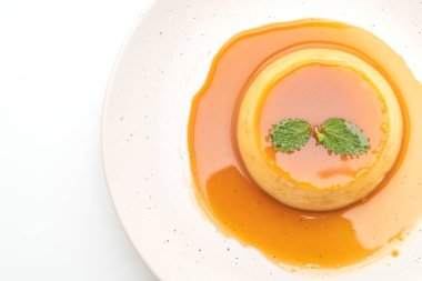 Ev yapımı karamel kremalı puding beyaz arka plan üzerinde izole