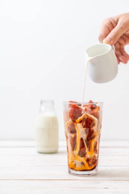 Tay çay buz küpü ile ahşap arka plan üzerinde süt