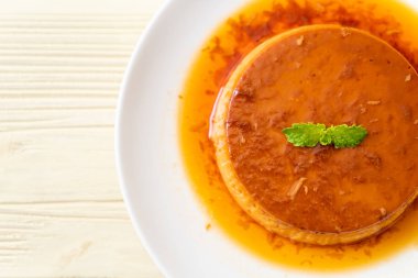 Ev yapımı karamel kremalı puding ahşap arka plan üzerinde