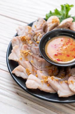 Soslu ve sebzeli haşlanmış balık sosu.