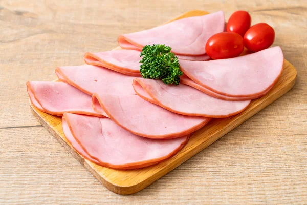 smoked ham sliced on wood board