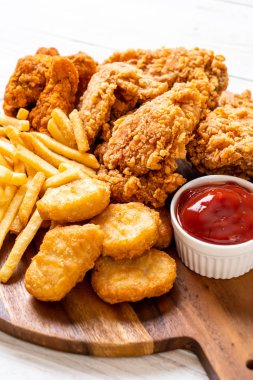 Kızarmış tavuk, patates kızartması ve nugget yemeği. Abur cubur ve sağlıksız yemek.