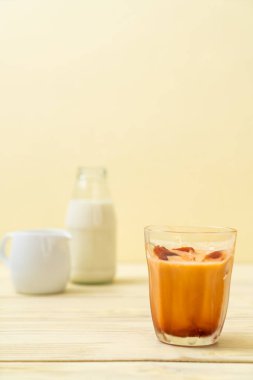 Tay çay buz küpü ile ahşap arka plan üzerinde süt