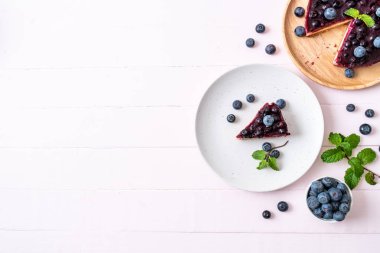 Ahşap arka planda ev yapımı yaban mersinli kek.