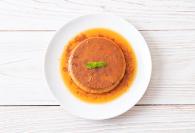 Ev yapımı karamel kremalı puding ahşap arka plan üzerinde