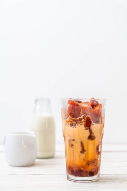 Tay çay buz küpü ile ahşap arka plan üzerinde süt