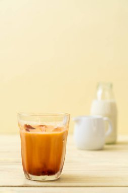 Tay çay buz küpü ile ahşap arka plan üzerinde süt