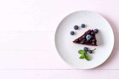 Ahşap arka planda ev yapımı yaban mersinli kek.