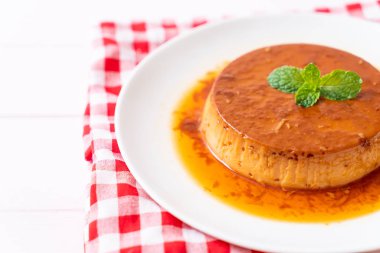 Ev yapımı karamel kremalı puding ahşap arka plan üzerinde