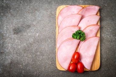 Ahşap tahta üzerinde dilimlenmiş jambon füme