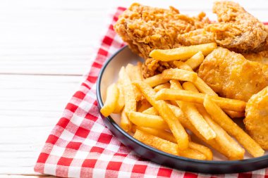 Kızarmış tavuk, patates kızartması ve nugget yemeği. Abur cubur ve sağlıksız yemek.