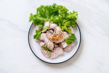 Soslu ve sebzeli haşlanmış balık sosu.