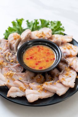 Soslu ve sebzeli haşlanmış balık sosu.