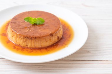 Ev yapımı karamel kremalı puding ahşap arka plan üzerinde