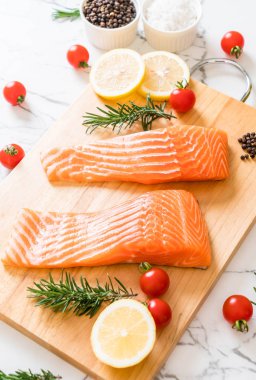 Limon domates Biberiye Biber ve tuz ahşap tahta üzerinde Çiğ somon fileto