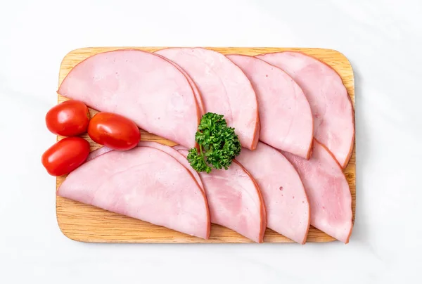 smoked ham sliced on wood board