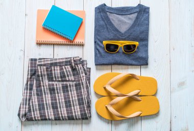 Gezgin, yaz tatili ahşap arka plan üzerinde erkek casual kıyafetler