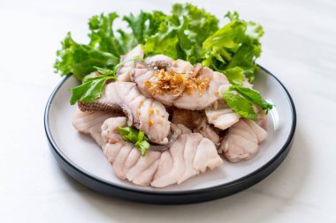 Soslu ve sebzeli haşlanmış balık sosu.