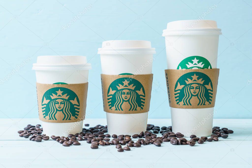 BANGKOK, THAILAND - JUN 5, 2018: White coffee cup with Starbucks logo on wood background. Starbucks is the world's largest coffee house with over 20,000 stores in 61 countries.