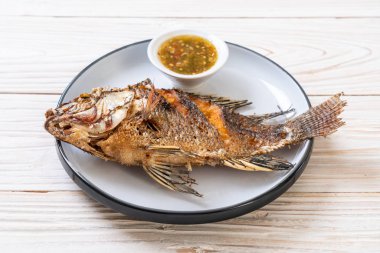 Kızarmış balık baharatlı deniz ürünleri sos ile