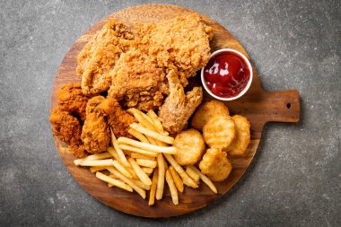 Kızarmış tavuk, patates kızartması ve nugget yemeği. Abur cubur ve sağlıksız yemek.