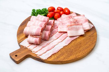 Ahşap tahta üzerinde çiğ domuz pastırma dilimlenmiş