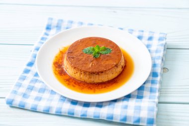 Ev yapımı karamel kremalı puding ahşap arka plan üzerinde