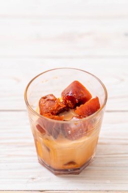 Tay çay buz küpü ile ahşap arka plan üzerinde süt